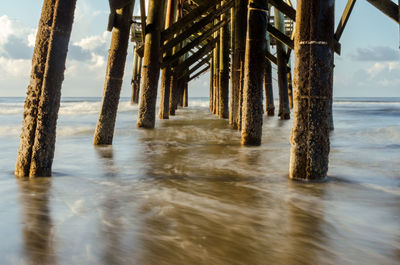 Silhouette pier on sea against sky