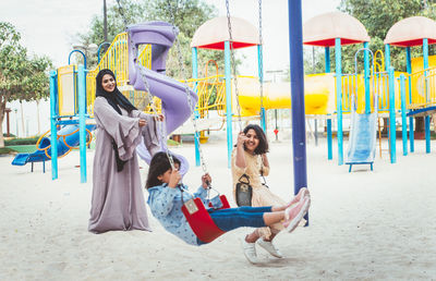 Mother with cheerful daughters enjoying at park
