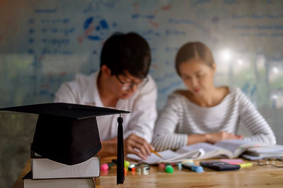 Friends studying with school supplies on table at home