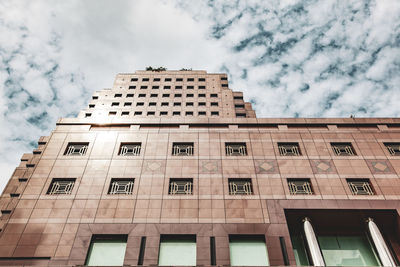 Low angle view of building against cloudy sky