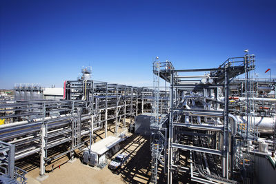 Power station against clear blue sky on sunny day