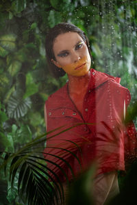 Portrait of young woman standing in tropical shower 