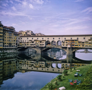 Bridge over river in city against sky