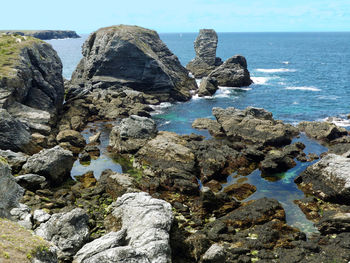 Rocks on sea shore against sky