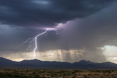 Lightning strikes the chiricahua mountains during a monsoon storm near willcox, arizona.