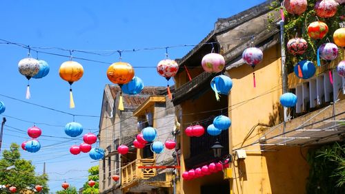 Low angle view of lanterns hanging by building