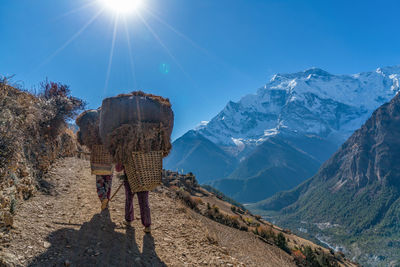 Rear view of woman walking on mountain against sky