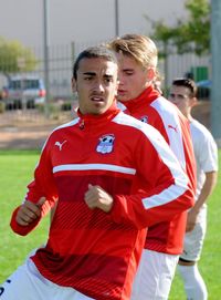 Portrait of young couple standing on soccer field