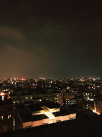 High angle view of illuminated buildings against sky at night