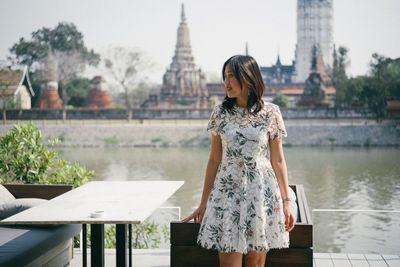 Midsection of woman standing against built structure