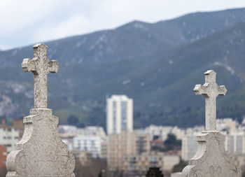 View of crosses on cemetery against hills and an apartment block, marseille, france