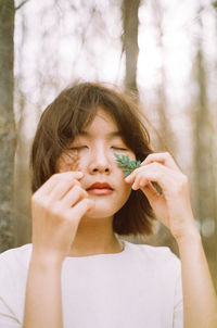 Portrait of a young woman holding a plant