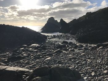 Scenic view of sea and mountains against sky