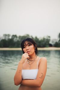 Portrait of young woman wearing bikini standing at beach