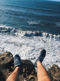 Low section of man on rock against sea