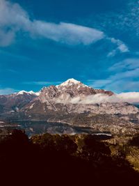 Scenic view of snowcapped mountains against blue sky