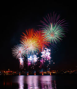 Firework display over river at night