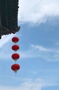 Low angle view of lanterns hanging against sky