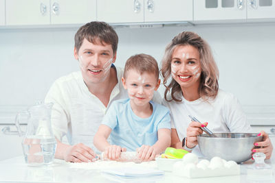 Portrait of happy family sitting at home