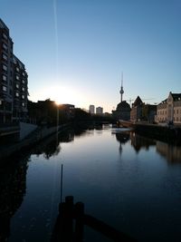 Reflection of buildings in city at sunset