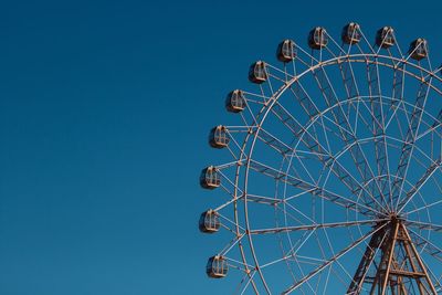 Low angle view of ferris wheel against blue sky