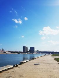 Scenic view of beach and buildings against blue sky