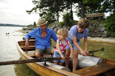 Germany, bavaria, murnau, grandfather with grandson and granddaughter in rowing boat