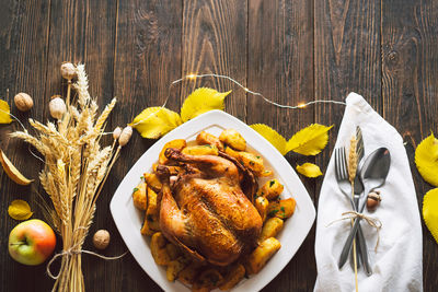 Autumn composition with leaves, ripe pumpkin and thanksgiving turkey on a dark wooden table.