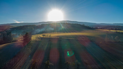 Scenic view of field against sky on sunny day