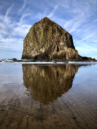 Rock formation on beach against sky