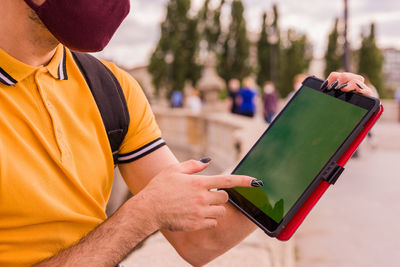 Midsection of man using digital tablet