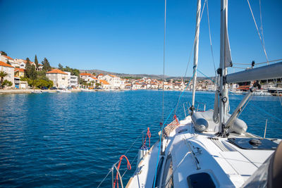 Sailboats sailing in sea against clear blue sky