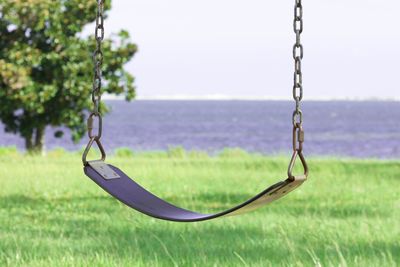 Empty swing over grassy field