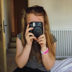 Young woman photographing at home