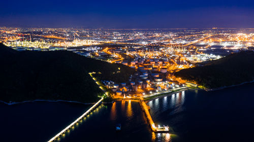 High angle view of illuminated city against sky at night