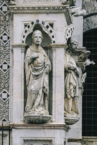 Low angle view of statue against historic building