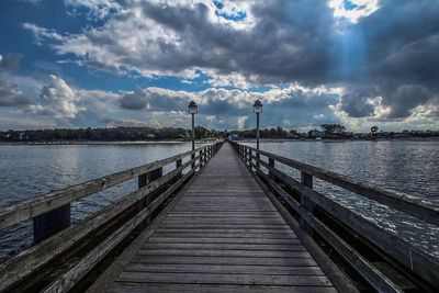 Pier over river against sky