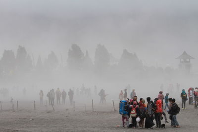 People walking on land against sky