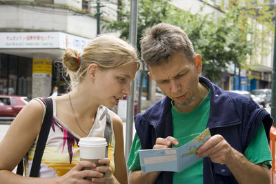 Close-up of young woman holding umbrella in cafe