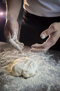 Hands of the cook kneading pizza dough close-up