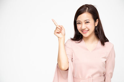 Portrait of a smiling young woman against white background