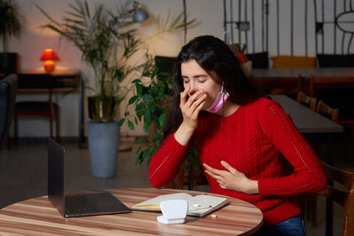 Sick woman sitting at home