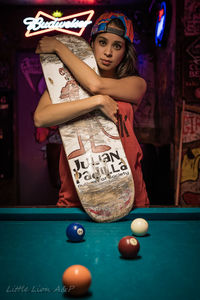 Young woman holding ball while standing on table