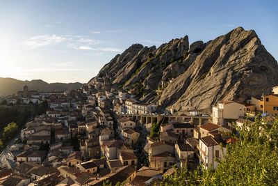 Aerial view of townscape by mountain against sky