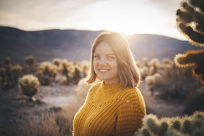 Portrait of smiling young woman against sky