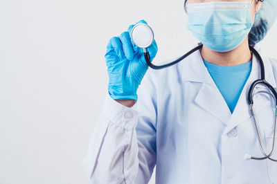 Midsection of person wearing mask against white background