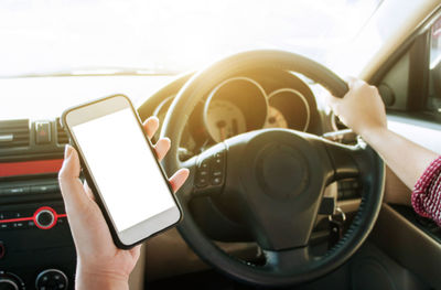 Midsection of man using mobile phone in bus