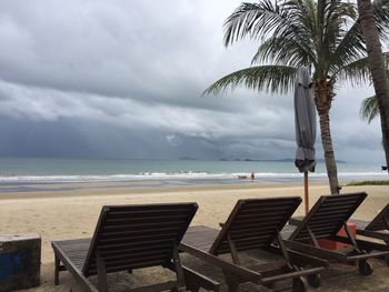 Chairs on beach against sky