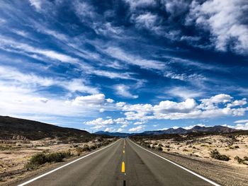 Empty road along landscape against sky