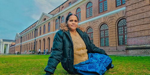 Portrait of woman standing against building